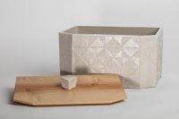 Brotkasten<br>
mit abgeschrägten Kanten auf einer Seite, aufwändiges Dreieck-Rautenmuster geritzt und porzellanengobiert, innen Zinnglasur, außen spielt die Oberfläche zwischen zinnglasiert, glatt, glänzend und fast unglasiert, matt und glatt.<br>
Ganz unaufdringlich durchgestaltet mit Kirschholz-Deckel<br>
Maße: 36x19x19,5 cm mit Deckel, ohne Knopf<br>
Preis incl. Versand: 320,-€