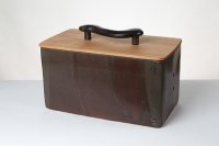 <br>
Brotbox mit Holzdeckel (hier Kirsche) und Keramikgriff<br>
Dieser Brotkasten besticht durch seine erdig braune Glasur. Die Schattierungen in ihrem Verlauf geben dem Topf  lebendige Farbigkeit, die sich angenehm zurückhält, nicht im Vordergrund steht. Innen ist der Topf weiß glasiert. Das braune Brot gibt eine Verbindung zu äußeren Oberfläche, und sieht im hellen cremeweiß sehr appetitlich aus. An der Kante nach innen gibt es ein schönes Ineinanderfließen der beiden Glasuren.<br>
Der keramische Griff ist ergonomisch sehr angenehm und schwungvoll geformt<br>
Maße in cm L / B / H: 36 / 18,5 / 19, mit Griff 22 cm.<br>
Preis: 255,-€  Incl. Versand