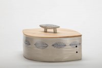 großer linsenförmiger Topf mit Ahorn-Deckel, blau gezeichnetes Muster umlaufend, handlicher Keramikgriff
für runde Brotlaibe und ein paar Semmeln daneben.
230,-€ incl. MWST