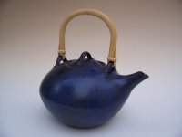 <br>
Klassische Teekannenform, <br>
blaue Engobe, Feldspatglasur, Ratanbügel zum Klappen
